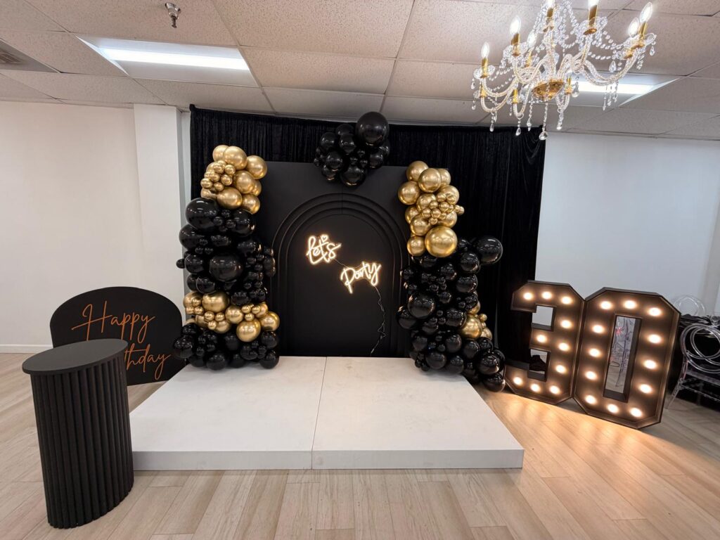 Black and gold birthday backdrop on the stage