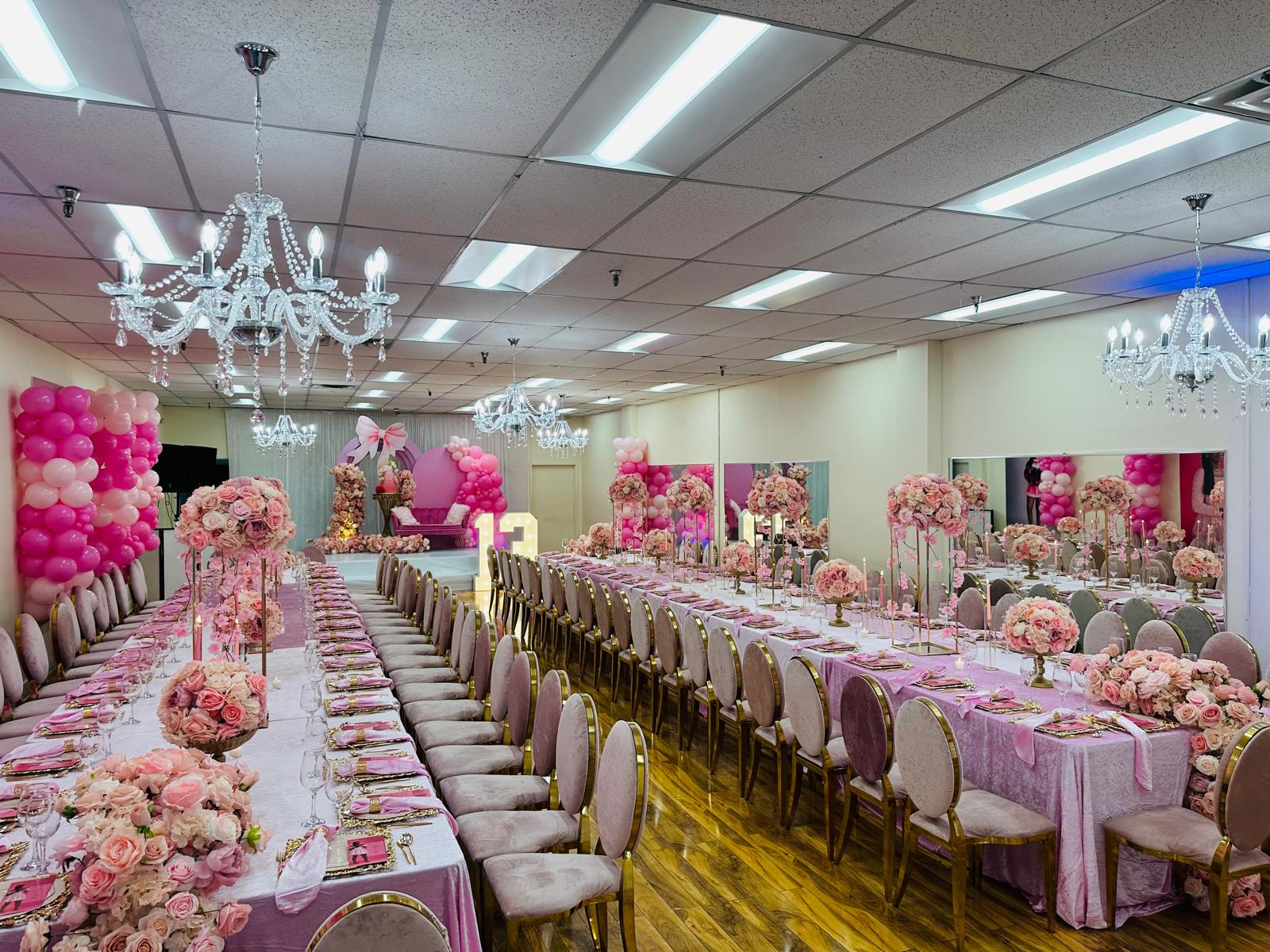 Full hall with two long banquet tables and chandeliers